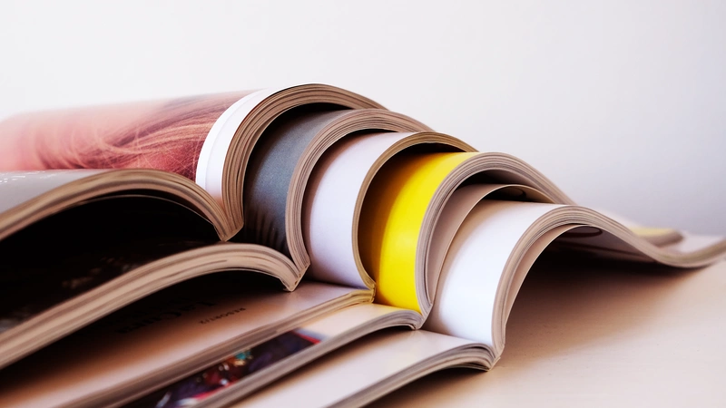 Bild von einem Stapel aufgeschlagener übereinandergelegter Zeitschriften