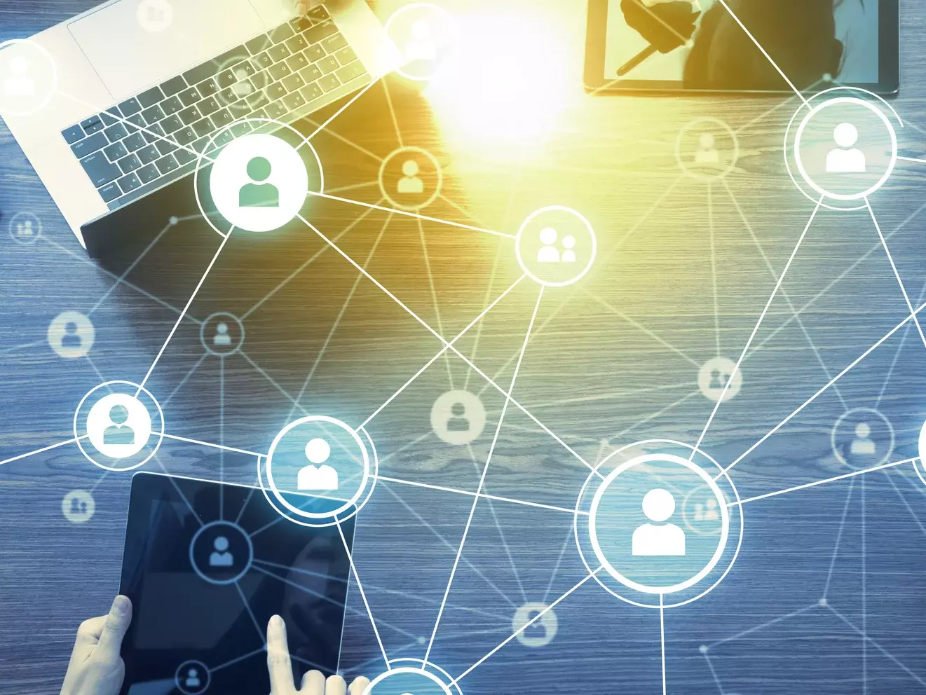 Digitale Vernetzungssymbole überlagern Geräte wie ein Tablet auf einem Tisch – Symbolbild für digitale Kommunikation und soziale Netzwerke.