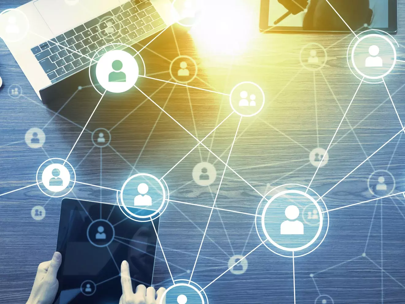 Digitale Vernetzungssymbole überlagern Geräte wie ein Tablet auf einem Tisch – Symbolbild für digitale Kommunikation und soziale Netzwerke.