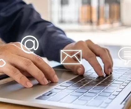 Person arbeitet an einem Laptop mit digitalen Symbolen für Dokumente und Kommunikation, die moderne Büroarbeit symbolisieren.