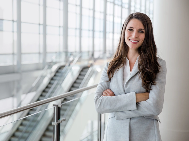 Bild einer Geschäftsfrau vor 2 Rolltreppen in einem Eingangsbereich