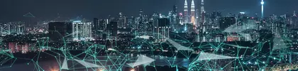 Nächtliche Stadtansicht mit leuchtender Skyline und überlagerten Netzwerklinien und Knotenpunkten – Symbol für Smart City.
