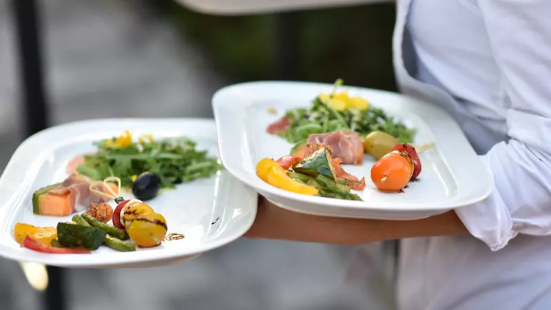 Bild einer Köchin, die Gourmet-Essen serviert