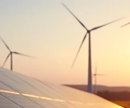 Solarpanels und Windräder in einer Landschaft bei Sonnenuntergang – Symbol für erneuerbare Energien und nachhaltige Energiegewinnung.