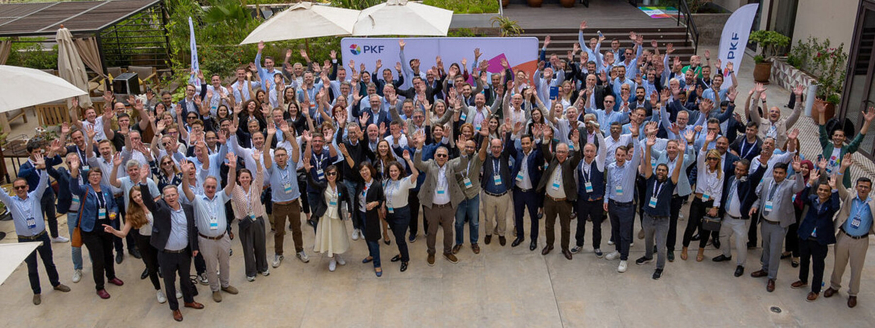 Menschen, die für ein Gruppenfoto als Teilnehmer einer Veranstaltung in einem modernen Innenraum posieren, viele tragen Namensschilder.